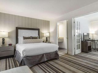 A contemporary hotel bedroom with a large bed, sleek furniture, and a bright, open feel